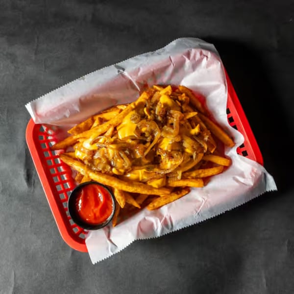 Stack'd Burger's loaded fries with melted cheese, caramelized onions, and a side of ketchup.